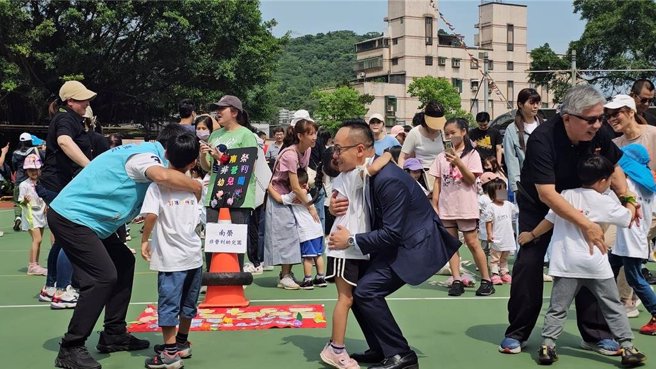 為了讓幼兒學習團隊合作，伊甸基金會11日在南榮國小舉辦「龍總逗陣來」親子運動會，現場有近2百組家庭參與同樂。議長童子瑋（前排左四）在現場與小朋友互動。（童子瑋辦公室提供／徐佑昇基隆傳真）