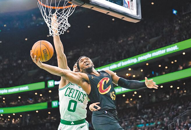 騎士後衛米契爾（右）在塞爾提克前鋒塔圖防守下反勾投籃。（路透）