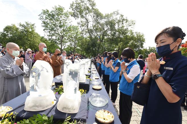 法师带领副县长与会眾礼佛足接花香。（苗栗县政府提供／李京升苗栗传真）