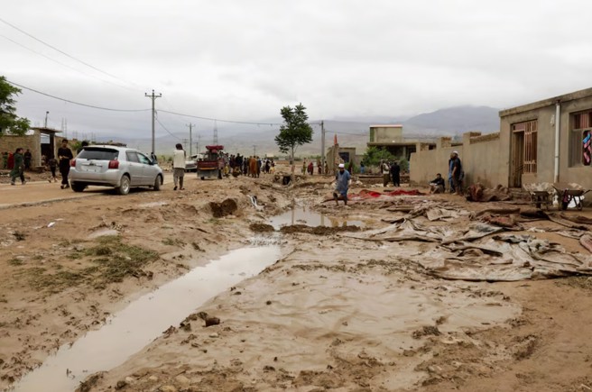 阿富汗巴格蘭省謝赫賈拉勒地區，人們正在清理洪水造成的泥濘。(圖/路透社)