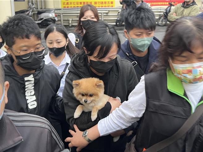 解剖结束后，刘姓妇人的大女儿抱着「糯米」，在旁人搀扶下离开殡仪馆。（王扬杰摄）