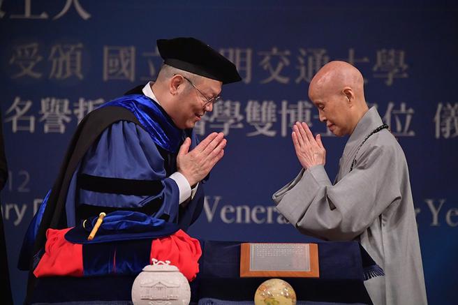 阳明交大校长林奇宏(左)颁发名誉哲学与医学双博士学位予慈济基金会创办人证严法师(右)，以表彰其在全球推动慈善、医疗、教育人文四大志业所做的卓越贡献。图/阳明交大提供