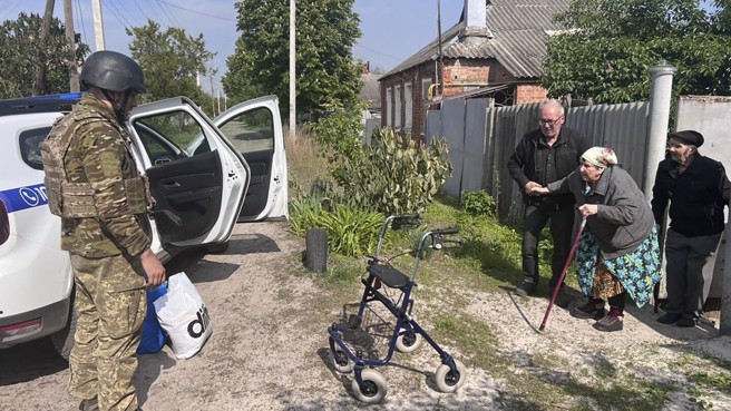 俄軍突然打擊哈爾科夫州邊境城鎮沃夫昌斯克，警衛隊趕緊協助居民疏散。(圖/美聯社)