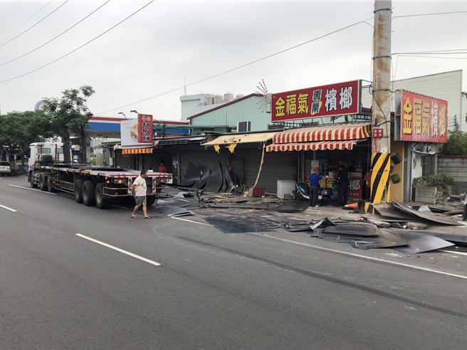 1輛曳引車14日中午行經台中市霧峰區林森路943號前路段，載運的鋼板竟噴出散落一地，波及路旁2部重機車及商家招牌與鐵門損壞，現場一片狼藉。（民眾提供／潘虹恩台中傳真）