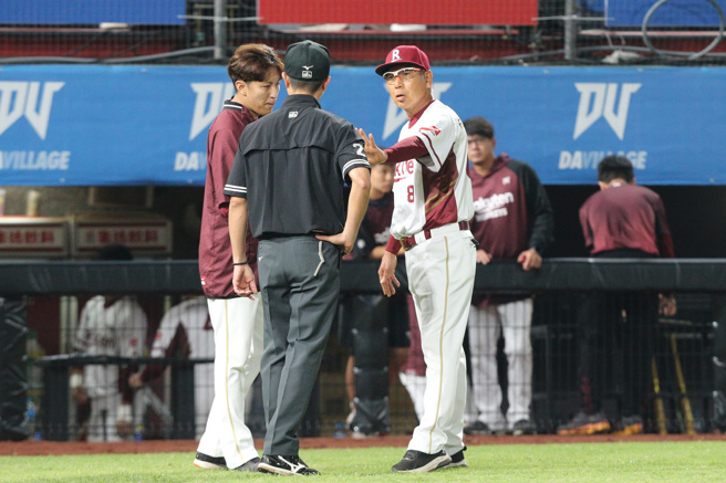 乐天桃猿马杰森跑回本垒时撞上捕手触杀出局，乐天桃猿总教练古久保健（右）二对判决有疑义上前与裁判交换意见。（陈麒全摄）
