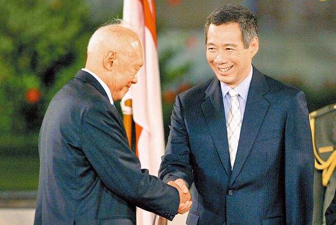 李光耀和两岸国民党、共产党领导人有许多互动，与其子李显龙先后扮演推手，将星国写入两岸谈判史。图为李显龙（右）在总统府与他的父亲、时任内阁资政李光耀握手。（美联社）