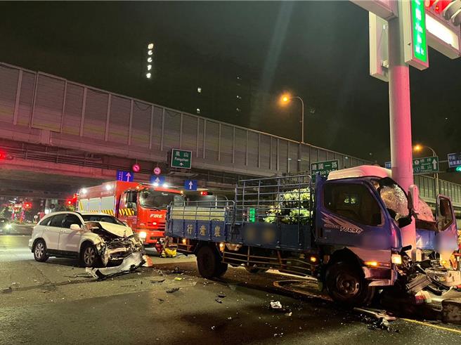高雄一輛休旅車下交流道疑似未禮讓直行車，擦撞到送菜小貨車，導致小貨車撞上號誌桿車頭凹陷，駕駛輕傷；休旅車駕駛則受困車內由警消人員協助脫困送醫。（警方提供／任義宇高雄傳真）
