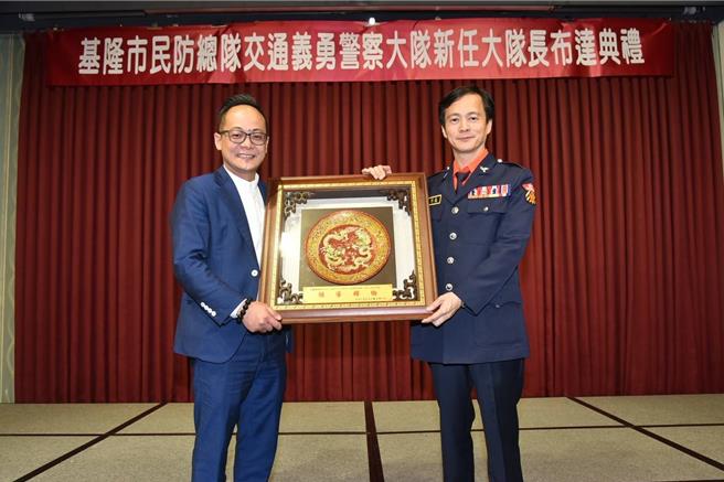 基隆市民防總隊交通義勇警察大隊16日舉行新任大隊長布達典禮，由資深藍營議員藍敏煌（右）接任，議長童子瑋（左）也出席致贈紀念品慶祝。（基隆市警察局提供／徐佑昇基隆傳真）