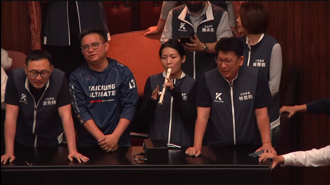 為了力拚國會改革五法搶在520前闖關三讀，國民黨與民眾黨立法院黨團發動議場「輪值守夜」搶優先排案權並把守在議場門口前，17日上午7點議場門打開，國民黨立委擋下民進黨的攻勢，搶先占上主席台並歡呼慶祝搶先排案登記成功。（翻攝自中時新聞網直播）