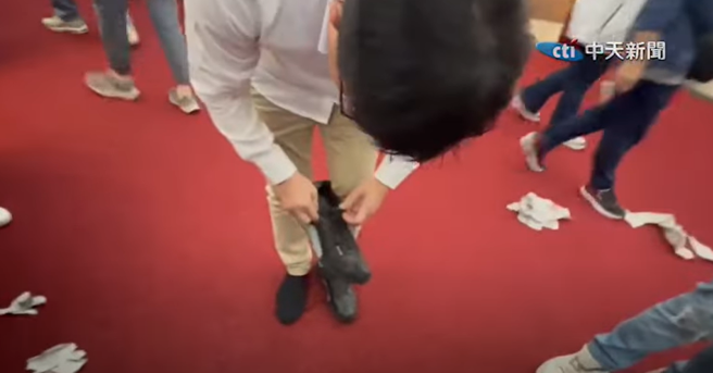 绿委郭国文找鞋画面。（取自中天新闻）