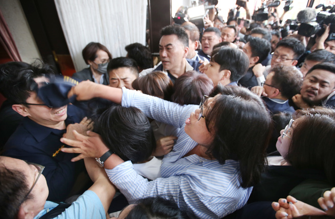 为了力拚国会改革五法抢在520前闯关三读，国民党、民眾党与民进党为抢优先排案权在议场门口发生推挤衝突，连驻卫警（左）都遭池鱼之殃遭到攻击。（姚志平摄）