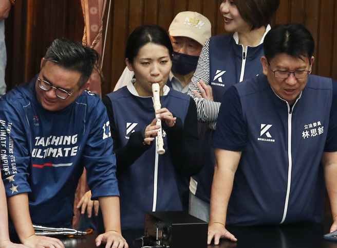 蓝、白抢先排案登记成功并占领主席台，徐巧芯（中）在主席台旁吹起直笛。（姚志平摄）