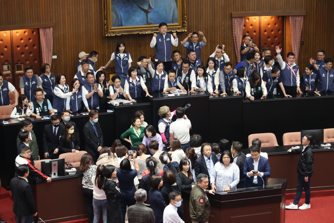 为了力拚国会改革五法抢在520前闯关三读，国民党与民眾党立法院党团发动议场「轮值守夜」抢优先排案权并把守在议场门口前，17日上午7点议场门打开，国民党立委挡下民进党的攻势，抢先占上主席台并欢呼庆祝抢先排案登记成功。（姚志平摄）