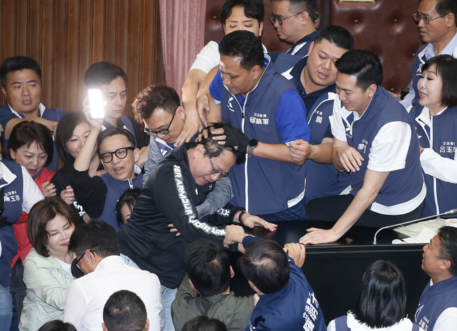 立法院17日院會下午休息時間再爆衝突，民進黨立委邱志偉（中左）想爬桌跨進主席台，遭國民黨立委邱鎮軍（中右）一掌按下阻擋。（資料照/姚志平攝）