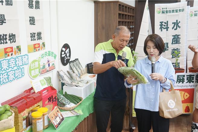以绿能养猪摘下了全国十大神农奖殊荣的苏鹏（左），向屏东县长周春米（右）介绍他的产品。（罗琦文摄）