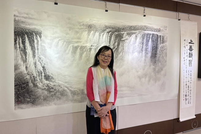 袁之靜老師與作品「上善若水─伊瓜蘇大瀑布」合影。(照片/中臺科技大學提供)