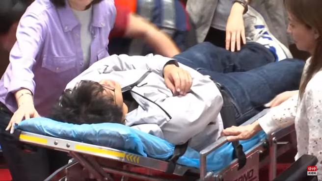 沈伯洋上担架送医。（取自直播）