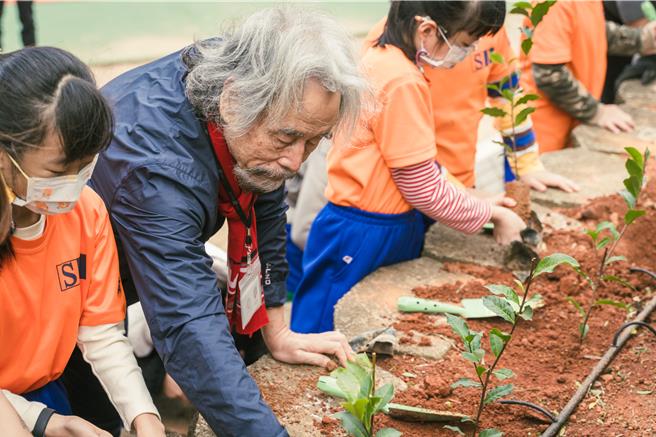 台湾光罩执行长吴国精生前经常资助苗栗县教育资源，与苗栗市新英国小学童们一起栽植茶树苗。（谢明俊摄）