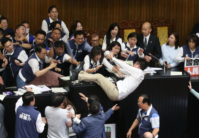 517立院大战，民进党立委郭国文跳上主席台，踩到桌上文件后摔得四脚朝天。(图／赵双杰摄)