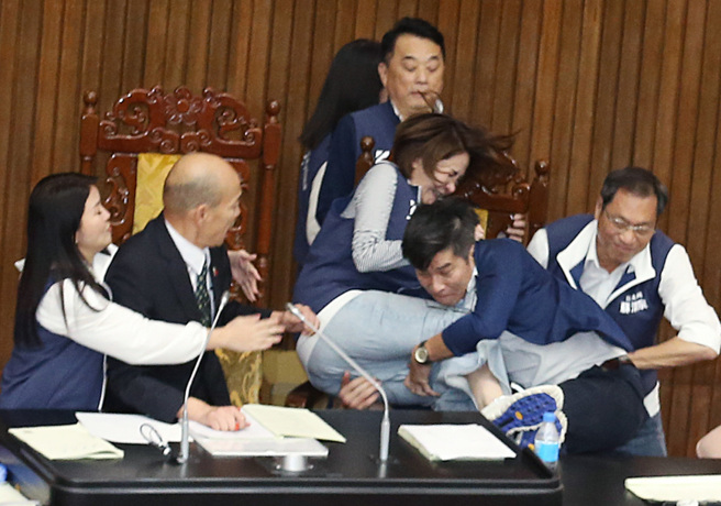 立法院17日院会表决大战一触即发，民进党立委锺佳滨（右二）翻上桌衝向主席台，国民党女立委陈菁徽（左三）被锺佳滨一把抱住，2人双双跌落桌下。（姚志平摄）