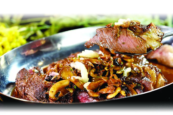 〈烤肋眼牛排．牛骨髓波尔多酱汁〉的肋眼牛排以直火炭烤，上桌时会搭配炒蘑菇。图／姚舜