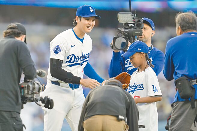 道奇不敵紅人吞下2連敗，大谷翔平（左）2打數0安打，但賽前贈送簽名球給病童艾伯特（右），讓艾伯特驚喜不已。（美聯社）