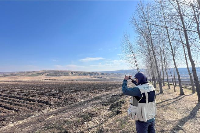 吴崇汉在大陆黑龙江省拜泉县田野寻找小土豆。（吴崇汉提供）