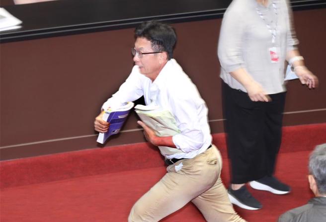郭国文在抢走公文后，立刻拔腿狂奔跑出议场。（中时资料照，姚志平摄）