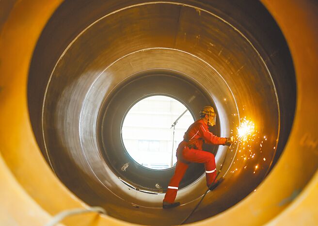 歐盟17日宣布對產自中國的部分鋼鐵製品、木地板展開反傾銷調查，有專家憂心中歐也將展開貿易戰。圖為天津海油工程青島建造場地，工人在進行鋼材打磨作業。（新華社）