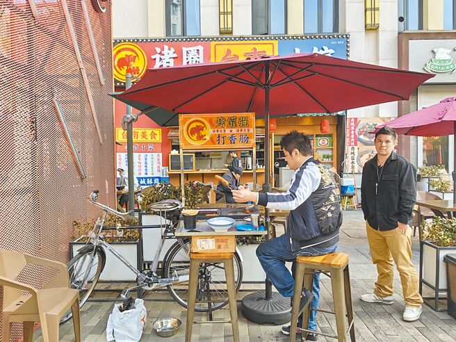 大陆消费降级，餐饮业力拚开拓平价市场。图为2023年11月起在大陆上海开设的「诸圈台南小馆」，以人民币9.9元的鲁肉饭为卖点，店前还摆设香肠摊。（受访者提供／朱绍圣上海传真）