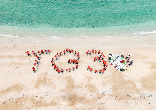 淨灘後的沙灘好美！全球人壽董總帶領志工在澎湖海灘共同合影，留下「TG 30」歡慶全球人壽30周年。(圖/全球人壽提供)
