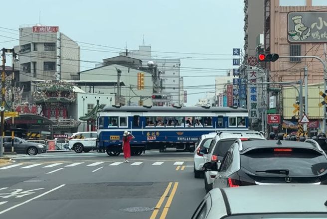 一名长髮红衣女站路中等待台糖小火车经过要合拍， 现场驾驶纷纷傻眼。(翻摄自爆废公社)