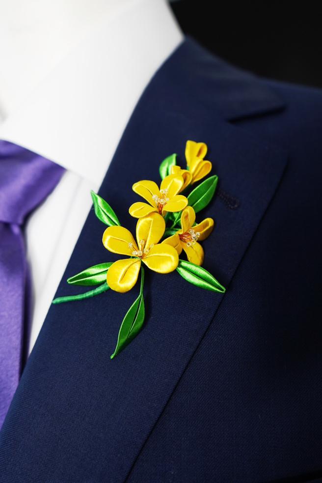 以纏花工藝打造的油菜花胸針，有「無私奉獻、前進夢想、無所畏懼」之意。（周裕穎提供）