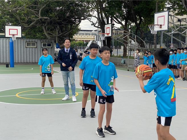 新竹市龍山國小籃球場20日完工啟用，副市長邱臣遠（左二）特別前往了解新球場使用狀況並與龍山籃球隊選手打球同樂。（陳育賢攝）