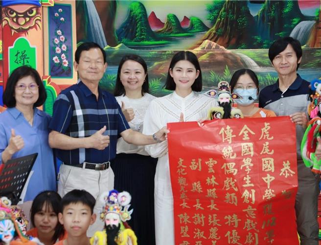 云林县今年共有虎尾国中等8所学校参与布袋戏教育扎根计画，拿下「全国学生创意戏剧比赛」5特优及3优等，超越台中、台南、高雄3直辖市，20日县文化观光处长陈璧君（后右三）前往虎尾国中张贴红榜。（云林县政府提供／张朝欣云林传真）