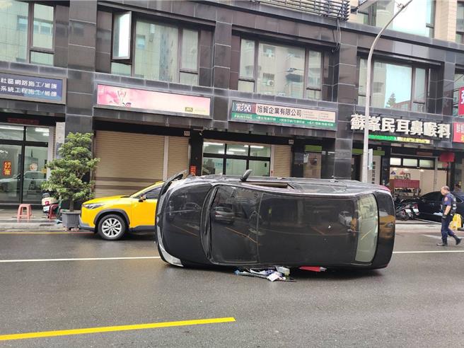 高雄左营一辆轿车（前）20日因为撞击路边违停的计程车后导致翻车，图为车祸现场。（翻摄照片／林瑞益高雄传真）