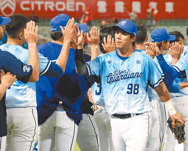 球賽結束後，高國麟與隊友擊掌慶祝。（劉宗龍攝）