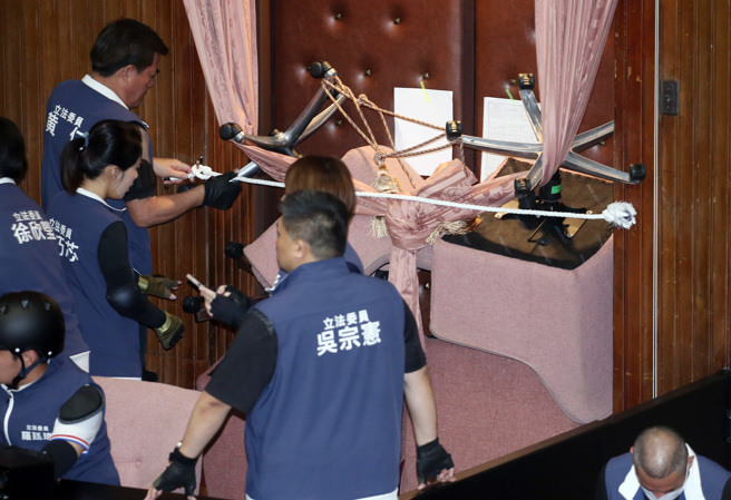 立法院21日院会继续处理国会改革相关法案，国民党与民眾党立委在上午7点进入议场后占领主席台，并以椅子及绳子加强防御工事，封住主席台两侧的门，防止民进党突袭。（姚志平摄）