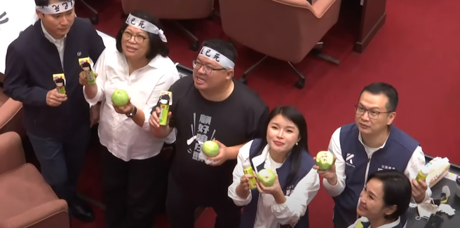 民進黨立委搬來整箱梅粉大酸民眾黨，但巧合的是，國民黨立委張嘉郡今也帶芭樂到議場，意外藍綠搭配，幾名藍綠立委也趁休息時共享芭樂加梅粉，場面意外溫馨。(截自中時新聞網直播)