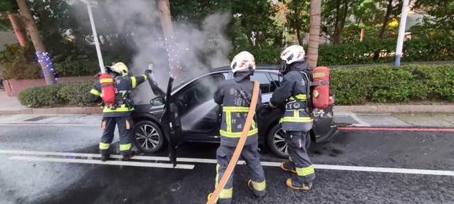 黑色轎車駕駛發現車輛故障，才剛停好車就起火燃燒，所幸消防隊即刻到場灌救。（翻攝畫面）