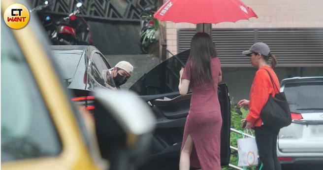 欧弟从副驾驶爬出来，长髮女子马上撑伞就怕男方淋到雨。（图／本刊摄影组）