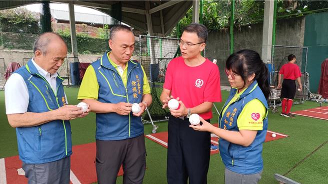 彰化縣員林市東山國小校長王建凱（右二）向全仁慈善會解釋訓練用球的使用狀況，強調每顆球都是用白色膠布包裹，重覆使用。（孫英哲攝）
