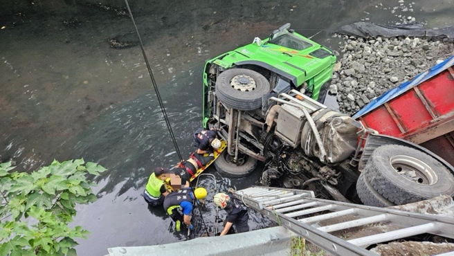 联结货车不慎撞破护栏摔进大排内，消防队进行救援。（翻摄画面）