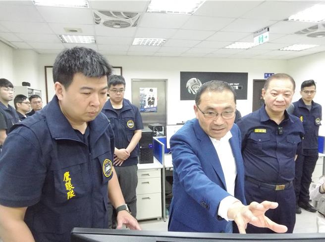 鹰眼队队长石春吉（左）向市长侯友宜（中）介绍科技执法、侦办系统及案件说明。（张铠乙摄）