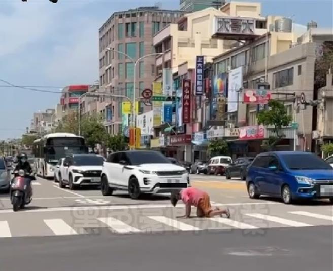 目击民眾PO出1段行车纪录器画面，上传《黑色豪门企业》脸书粉专，在台中清水区中山路的斑马线上，22日出现1名女子跪在斑马线上「朝拜」民眾将影片PO在网路上引发讨论。（摘自《黑色豪门企业》脸书粉专）