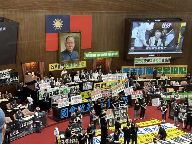 立法院會今下午繼續處理國會改革法案，民進黨立委全體換裝，身穿印有「反黑箱、反擴權」的黑衣，兩手握著藍白拖拍打桌子。（楊亞璇攝）