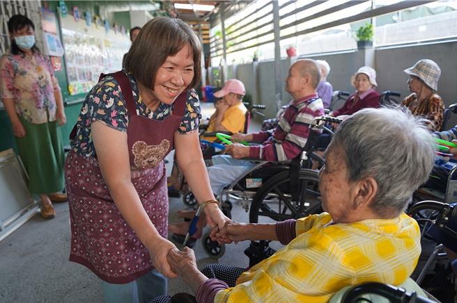 刘月华（左）同理心服务行动不便的长者，让长辈感受揪甘心。（屏东县政府提供／罗琦文屏东传真）
