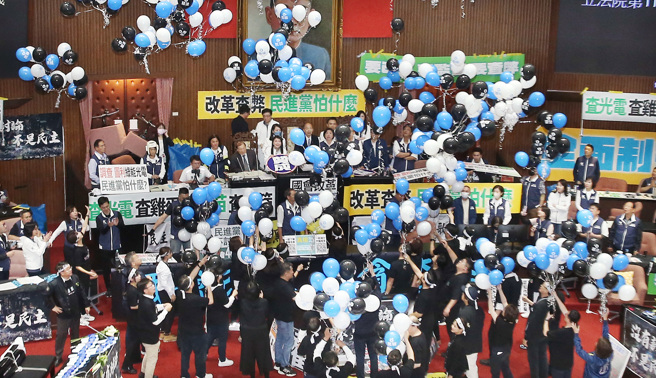 立法院24日院會繼續處理國會改革法案，冗長表決大戰晚餐休息時間之後，民進黨立委高喊「反黑箱，反擴權」並帶著藍白黑三色氣球進入議場，隨後當場施放氣球。（姚志平攝）