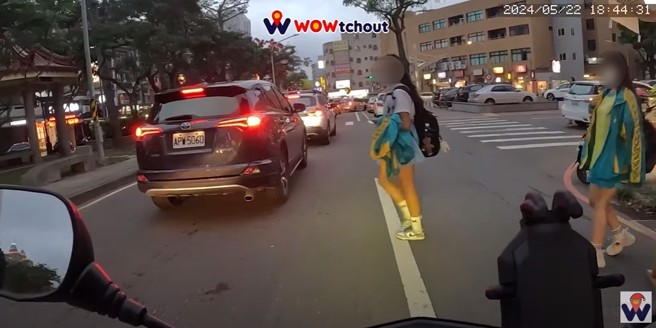 桃園一名女學生違規穿越馬路，害騎士緊急煞車，後方追撞，女學生只回頭看一眼就冷漠離去。（翻攝WoWtchout - 地圖型行車影像分享平台）