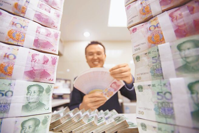 大陸國家發改委、央行等多部門23日發布《通知》表示，要推動貸款利率穩中有降。圖為銀行工作人員清點人民幣。（中新社）